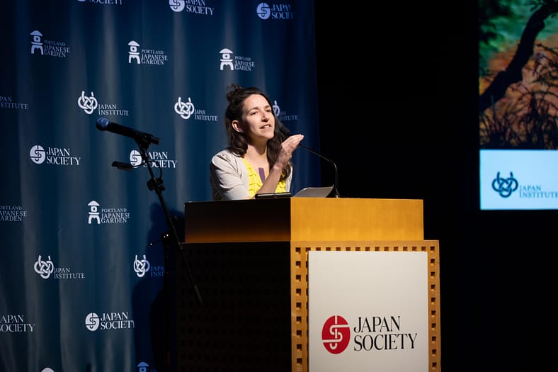 Nomi Stone reading a poem at a podium.